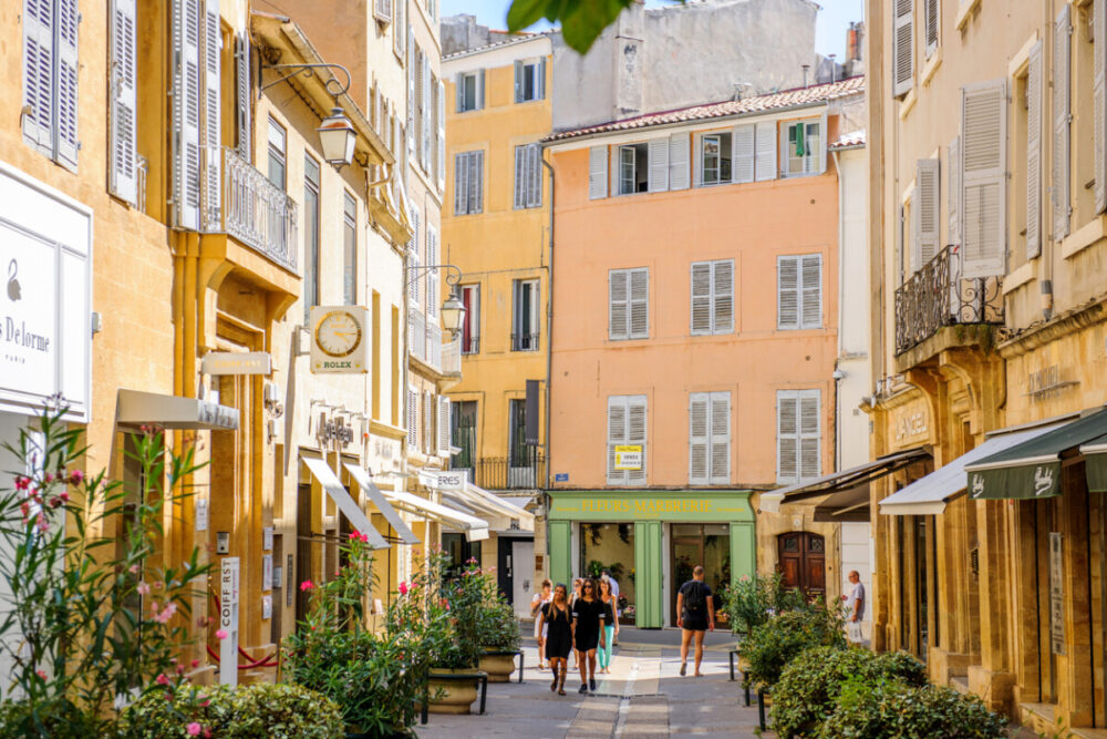 Aix, France - July 17, 2014: Beautiful shopping area in Aix-En-Provence with tourists walking betweens luxury shops on a warm summer day on Rue Nazareth
