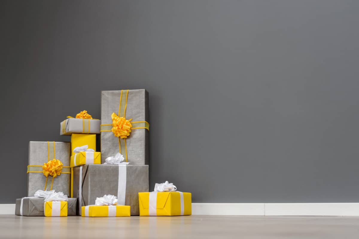 gray and yellow gifts set against a gray wall