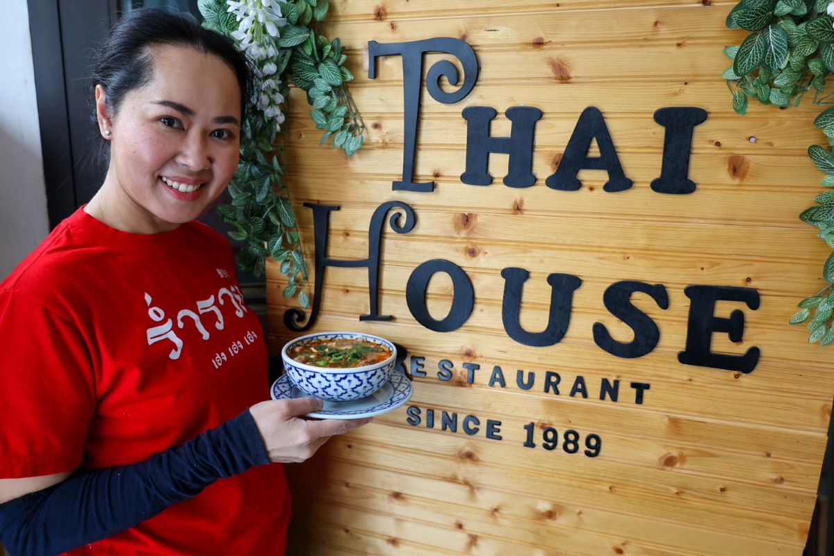 Food in Fairbanks, Alaska. A server at Thai House poses with an entree.