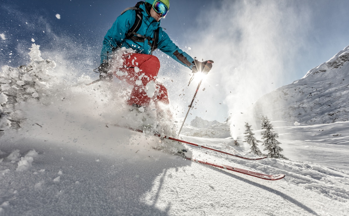 Man freeride skier running downhill on sunny Alps slope.