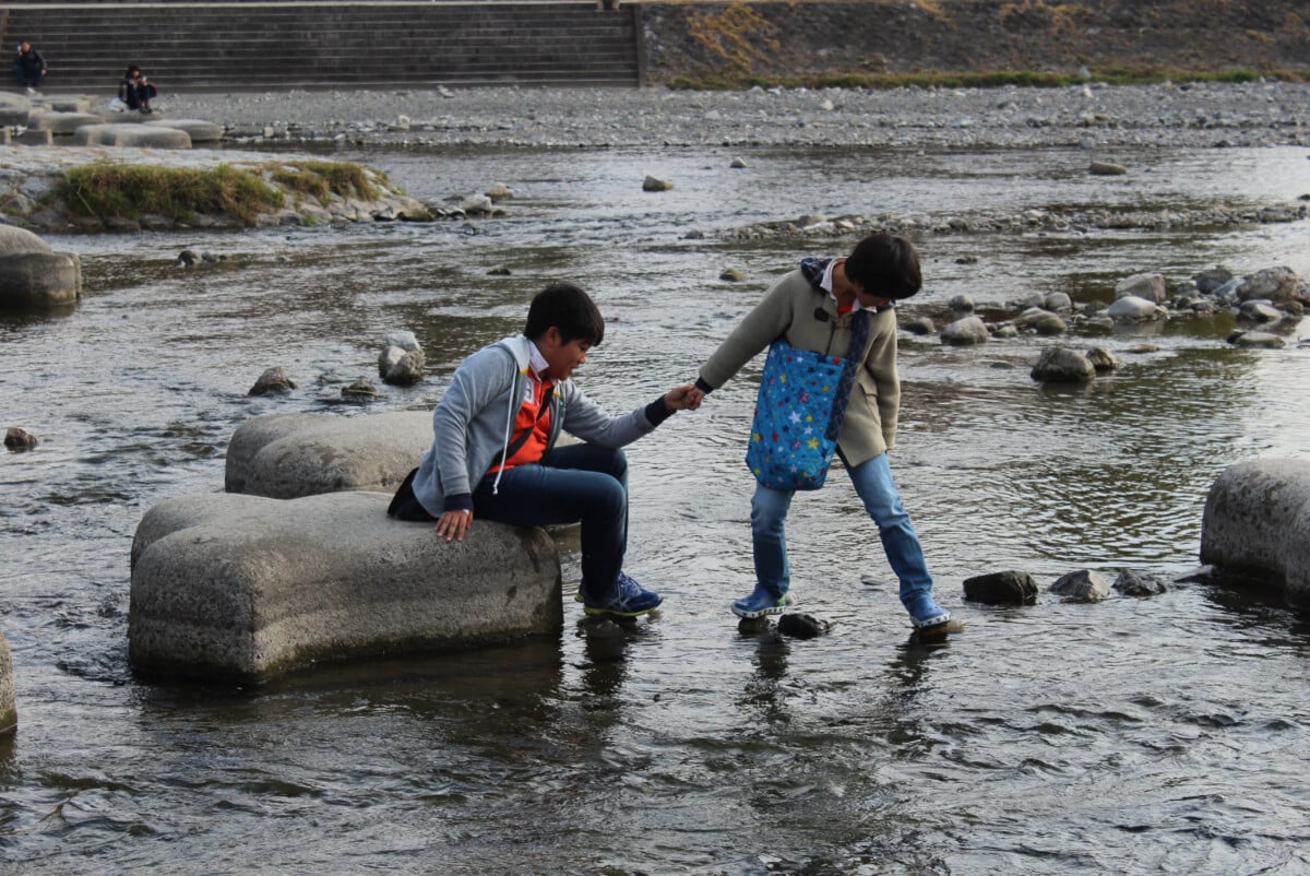 While waiting for my wife to get her red bean pancake at a street vendor in Kyoto I walked to the nearby river and took this photo. I didn't stick around long enough to see if the boys made it to the big rock without getting wet.
