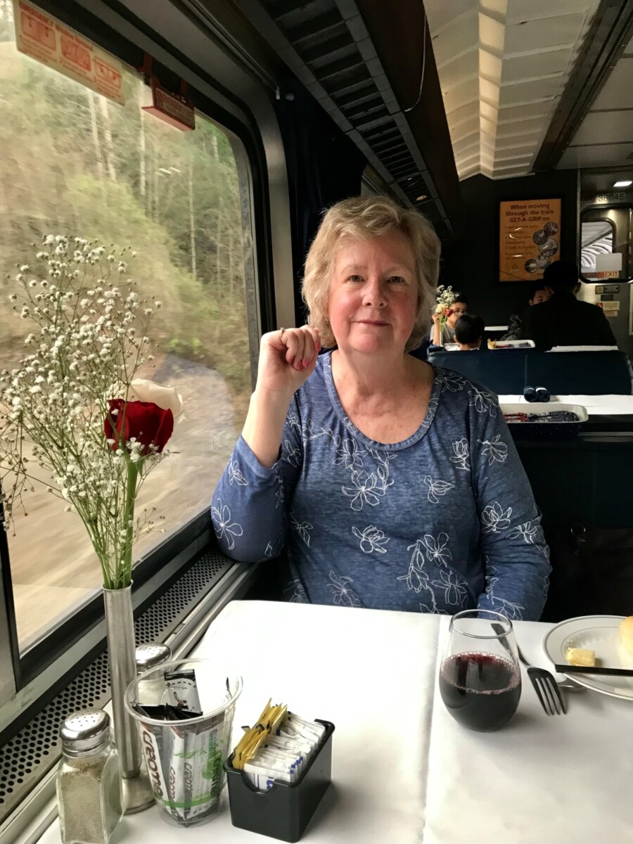 Elizabeth enjoying a glass of wine and awaiting the steak dinner on the Amtrak Coast Starlight.