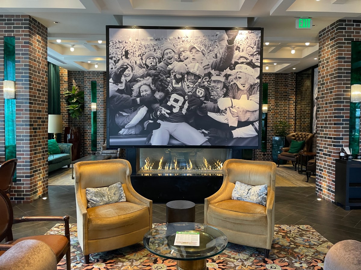 Lodge Kohler lobby with gold velvet armchairs and a large black and white photo of football players.