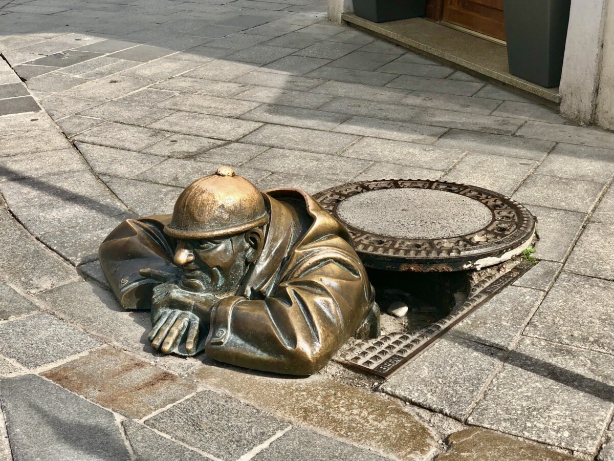 The man peering out of a manhole cover by Viktor Hulík. Photo by Susan Lanier-Graham