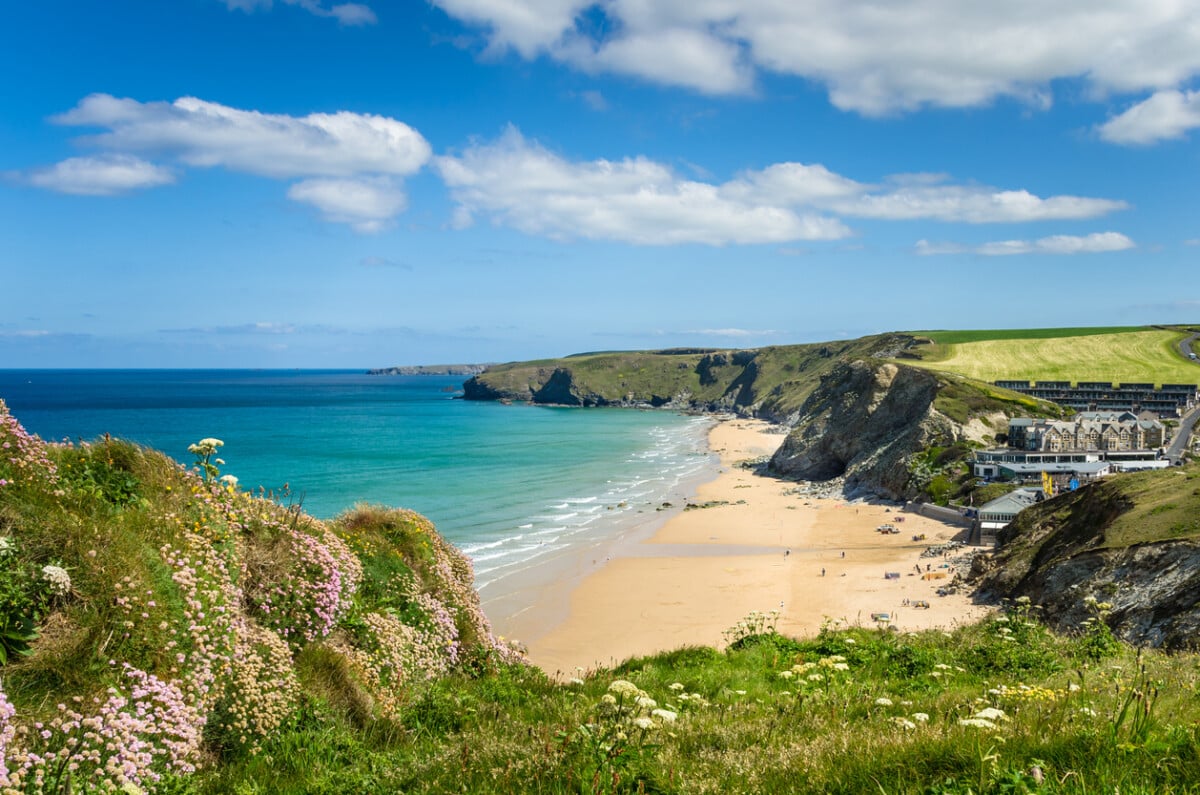 Photo of a Stretch of Coast in Cornwall with a Sandy Beach at the foot of high cliffs.