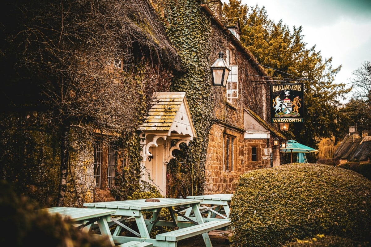 Cotswold pub, shaped hedges, garden gate, thatched roof, stone, tree, old, pub, benches, ivy