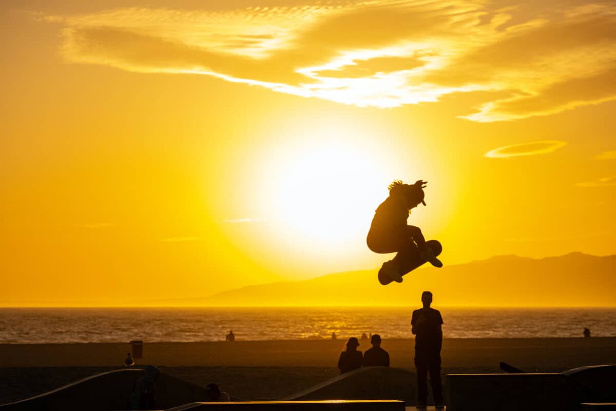 A skater in Venice Beach performs a jump in front of the setting sun
