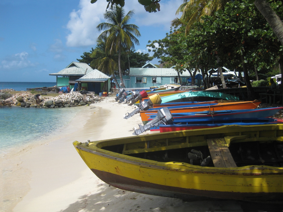 Colorful fishing boats and shacks on a white sand Beach on an exclusive Caribbean island